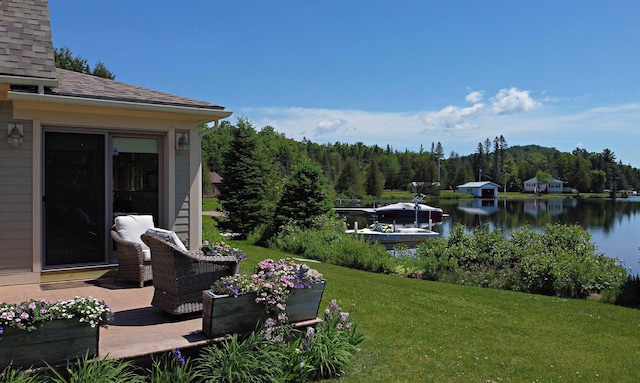 view of yard with a forest view and a water view