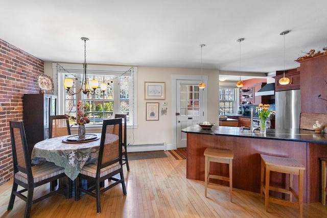 98 Hollis St, Manchester, NH 03101 - dining space featuring a baseboard heating unit, light wood-style floors, and a notable chandelier