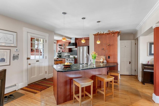 98 Hollis St, Manchester, NH 03101 - kitchen featuring a kitchen bar, a peninsula, wall chimney exhaust hood, and light wood finished floors