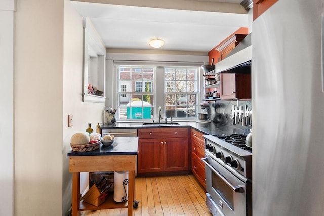 98 Hollis St, Manchester, NH 03101 - kitchen featuring stainless steel appliances, open shelves, dark countertops, wall chimney range hood, and a sink
