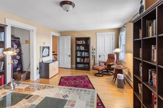 98 Hollis St, Manchester, NH 03101 - living area featuring baseboards, wood finished floors, and a baseboard radiator