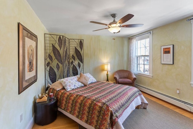 98 Hollis St, Manchester, NH 03101 - bedroom featuring a baseboard radiator, wood finished floors, and ceiling fan