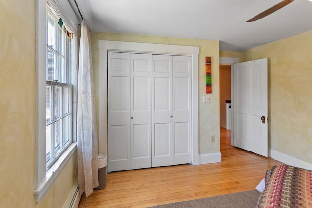 98 Hollis St, Manchester, NH 03101 - unfurnished bedroom featuring light wood-type flooring, a closet, baseboards, and ceiling fan