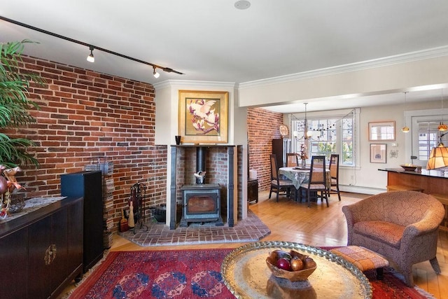 98 Hollis St, Manchester, NH 03101 - living room with wood finished floors, a baseboard heating unit, brick wall, a wood stove, and rail lighting