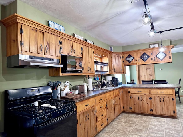 14 Summer St, Northumberland, NH 03582 - kitchen with a peninsula, dark countertops, brown cabinetry, under cabinet range hood, and black appliances