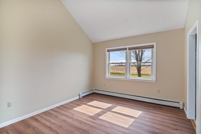 interior space featuring baseboard heating, lofted ceiling, wood finished floors, and baseboards