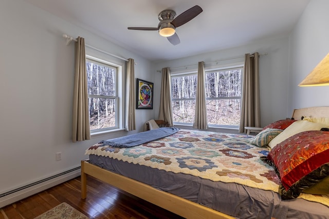 bedroom with ceiling fan, wood finished floors, and a baseboard radiator
