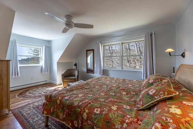 bedroom featuring baseboard heating, ceiling fan, and wood finished floors