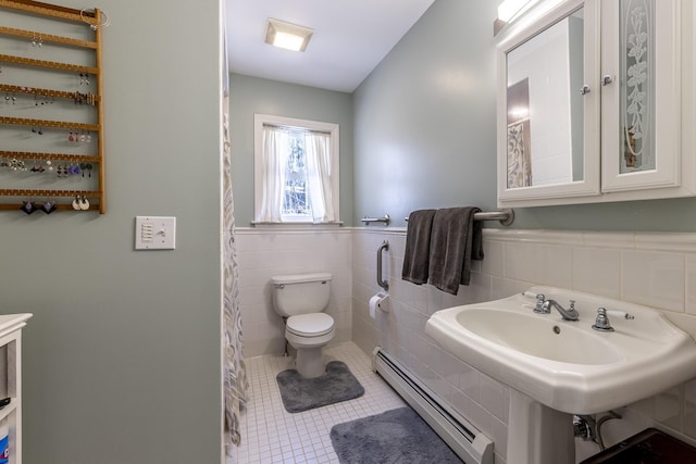 bathroom with a baseboard radiator, tile walls, a wainscoted wall, toilet, and tile patterned flooring