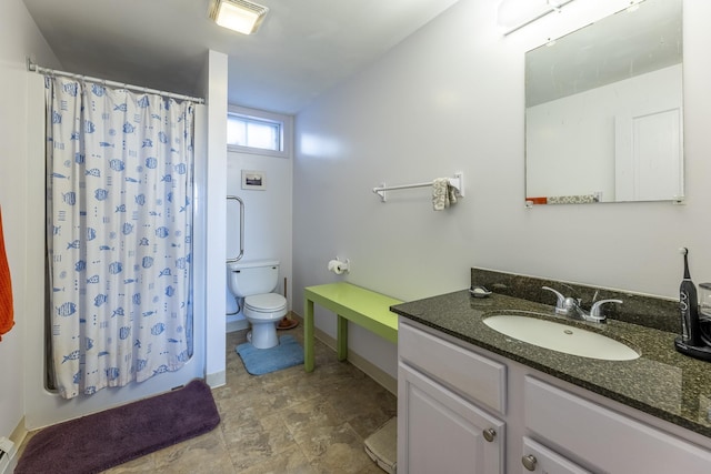 bathroom with toilet, baseboards, stone finish flooring, vanity, and a baseboard radiator