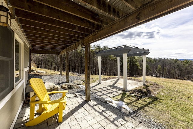 view of patio with a forest view and a pergola