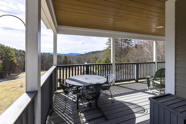 wooden deck with outdoor dining area and a mountain view