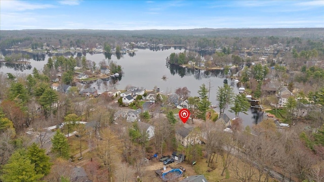 drone / aerial view featuring a view of trees, a water view, and a residential view