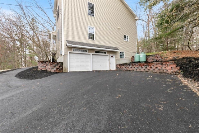 view of property exterior featuring a garage and driveway