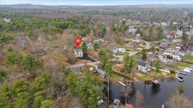 drone / aerial view with a residential view, a forest view, and a water view