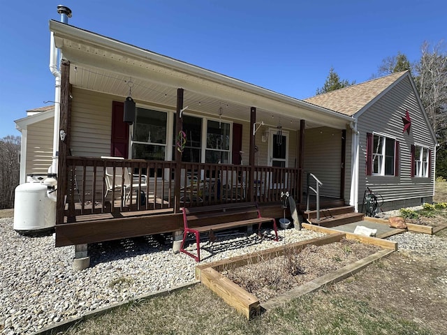 ranch-style home with a porch and a shingled roof