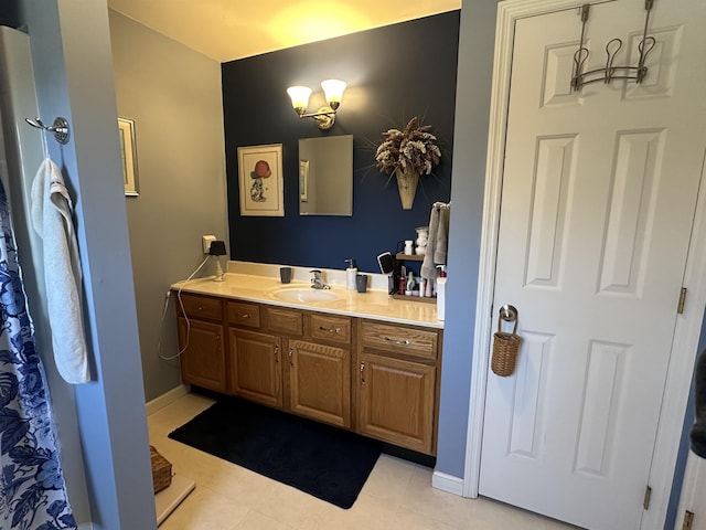 full bath with tile patterned flooring, baseboards, and vanity