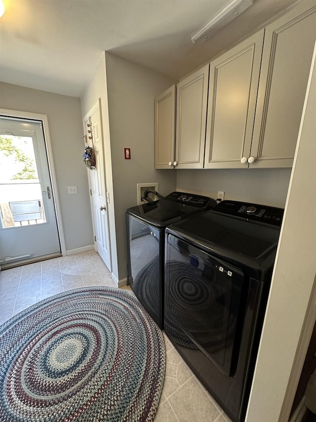 washroom with baseboards, cabinet space, washer and clothes dryer, and light tile patterned floors