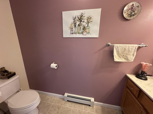 bathroom featuring baseboard heating, baseboards, vanity, and toilet