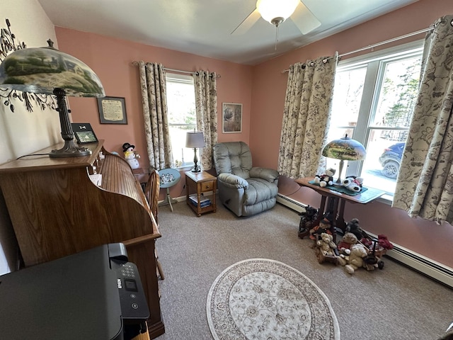 living area with a baseboard heating unit, carpet floors, and a ceiling fan