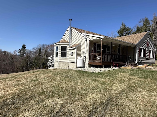 view of side of property featuring roof with shingles and a yard