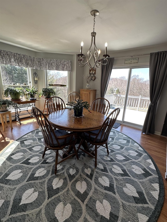 dining room featuring plenty of natural light, wood finished floors, and an inviting chandelier
