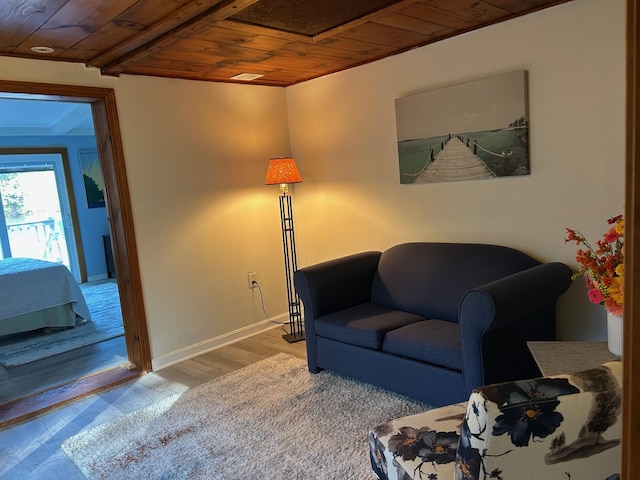 sitting room with baseboards, wooden ceiling, and wood finished floors