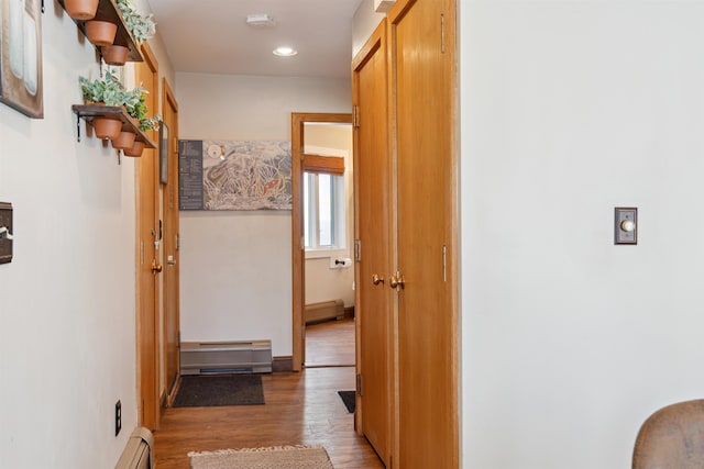 corridor with baseboard heating, a baseboard radiator, recessed lighting, and light wood-style flooring