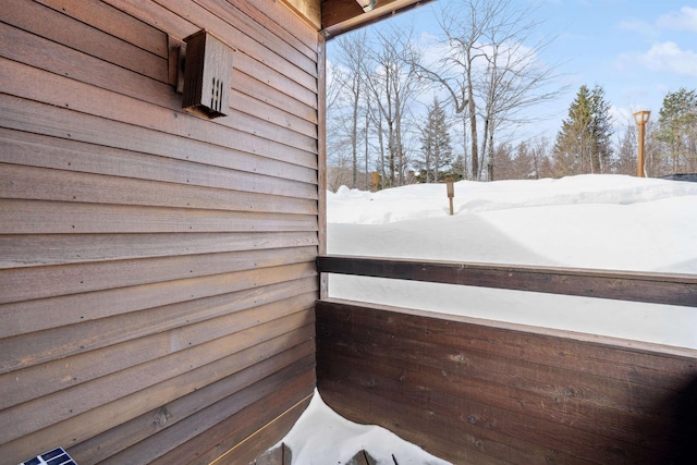 view of snow covered back of property