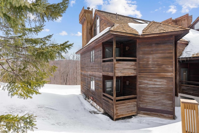 snow covered property featuring a chimney