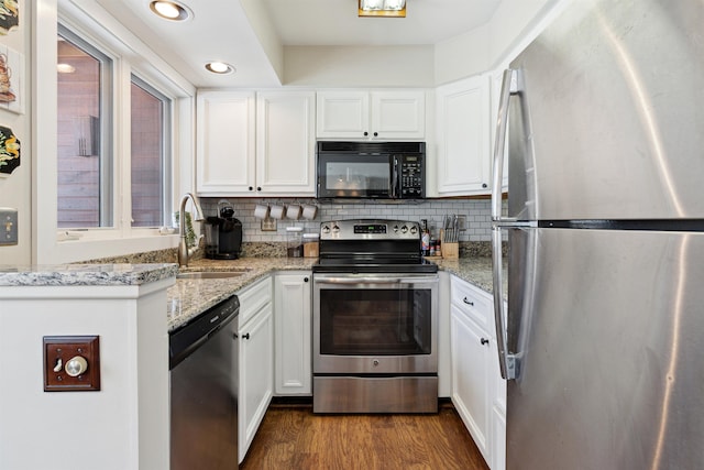 kitchen featuring white cabinets, stainless steel appliances, a sink, dark wood-type flooring, and decorative backsplash
