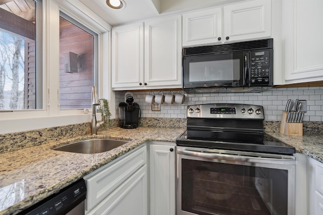 kitchen featuring white cabinets, a sink, light stone countertops, tasteful backsplash, and appliances with stainless steel finishes