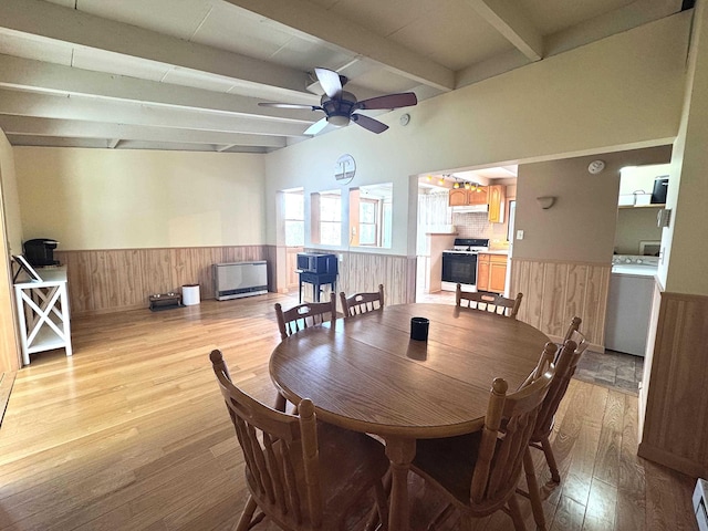 dining space featuring beamed ceiling, a wainscoted wall, light wood finished floors, and washer / clothes dryer