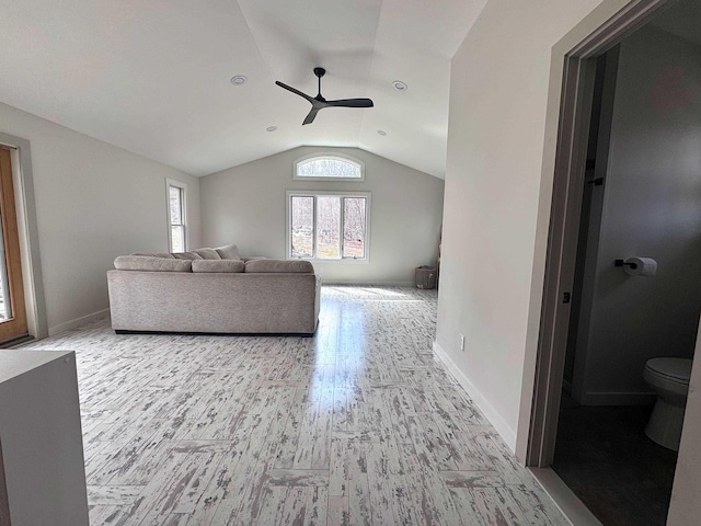 living area featuring lofted ceiling, baseboards, wood finished floors, and ceiling fan