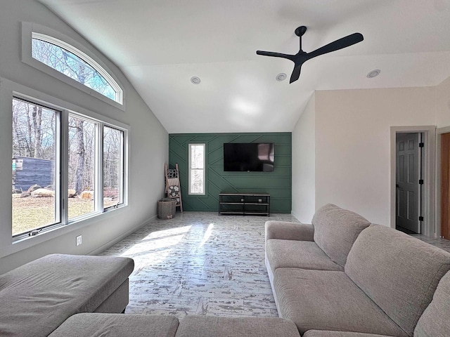 carpeted living room with ceiling fan, vaulted ceiling, and a wealth of natural light