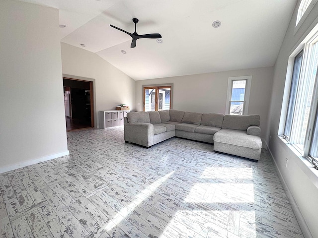 living room with vaulted ceiling, a ceiling fan, and baseboards