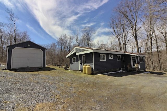 exterior space featuring driveway, an outbuilding, entry steps, and a garage
