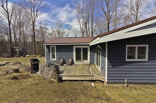 back of house featuring a wooden deck and metal roof