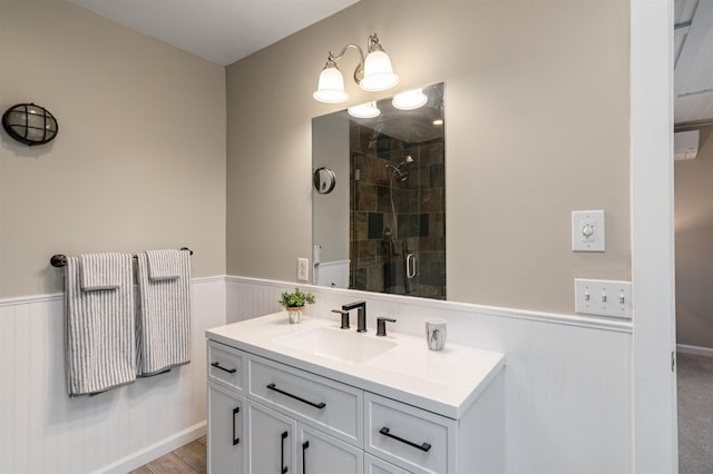 bathroom featuring vanity, a wainscoted wall, and a stall shower