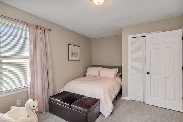 bedroom featuring multiple windows, a closet, and light carpet