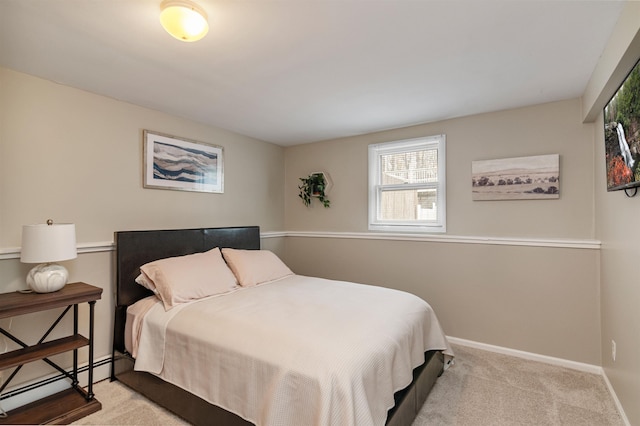 bedroom with a baseboard heating unit, carpet floors, and baseboards