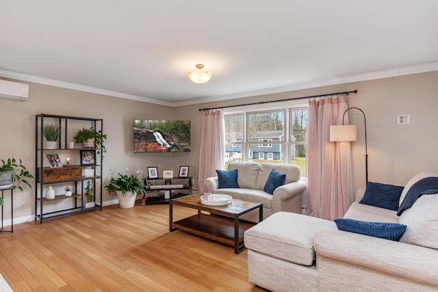 living room featuring baseboards, light wood-style flooring, ornamental molding, and a wall unit AC