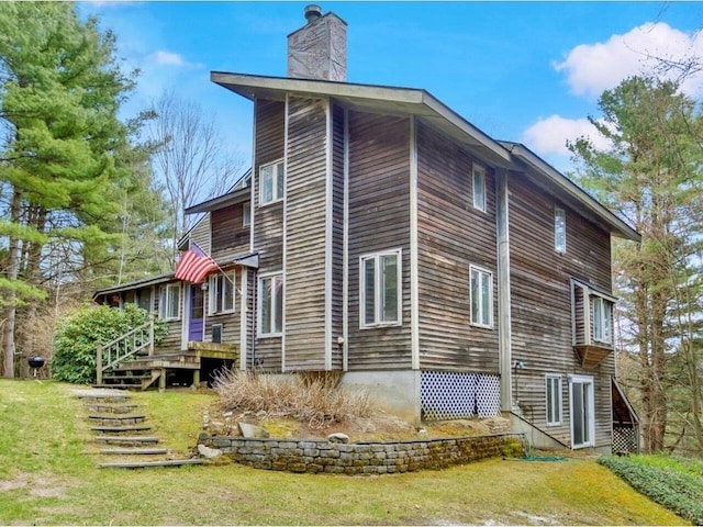 view of side of property featuring a chimney and stairs
