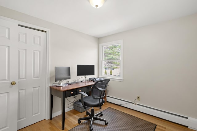 office space featuring a baseboard radiator and light wood-style floors