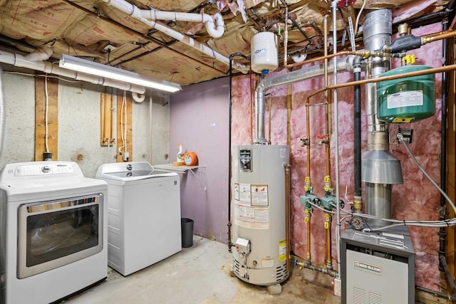 clothes washing area with gas water heater, washer and dryer, and laundry area