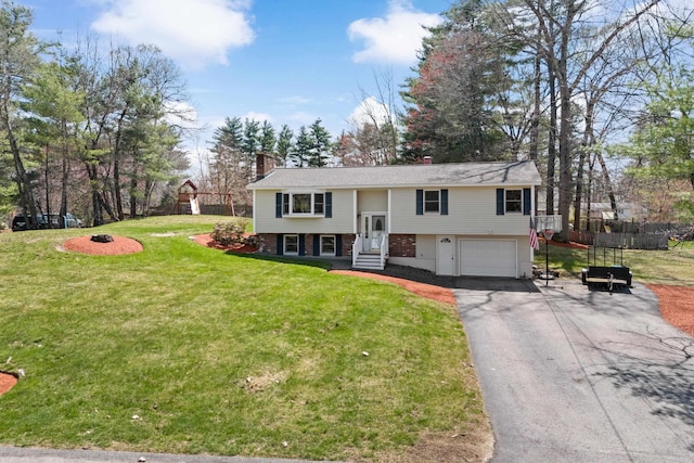 split foyer home featuring a chimney, aphalt driveway, fence, an attached garage, and a front yard