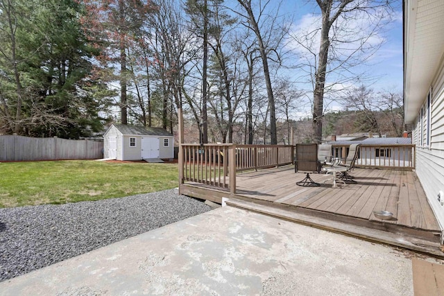 wooden deck with a shed, a lawn, an outdoor structure, fence, and a patio