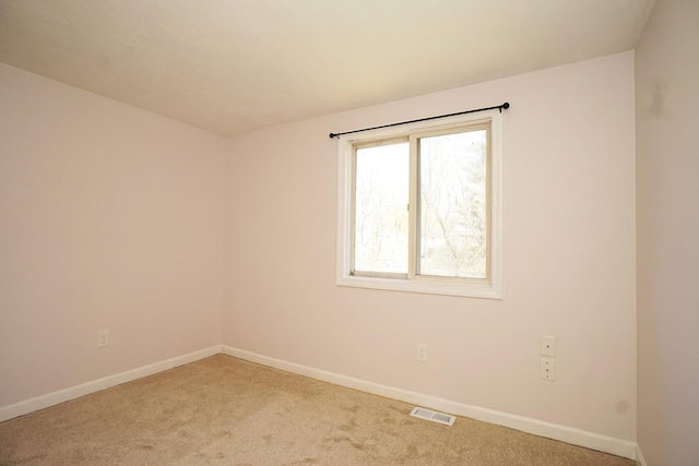 carpeted empty room featuring visible vents and baseboards