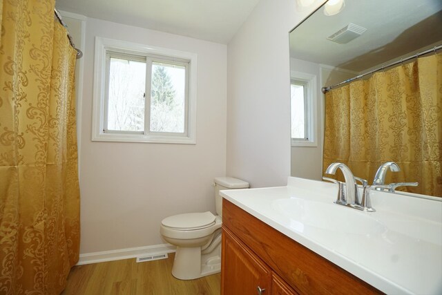 bathroom featuring wood finished floors, visible vents, a wealth of natural light, and toilet