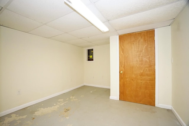 empty room with concrete flooring, electric panel, and a paneled ceiling